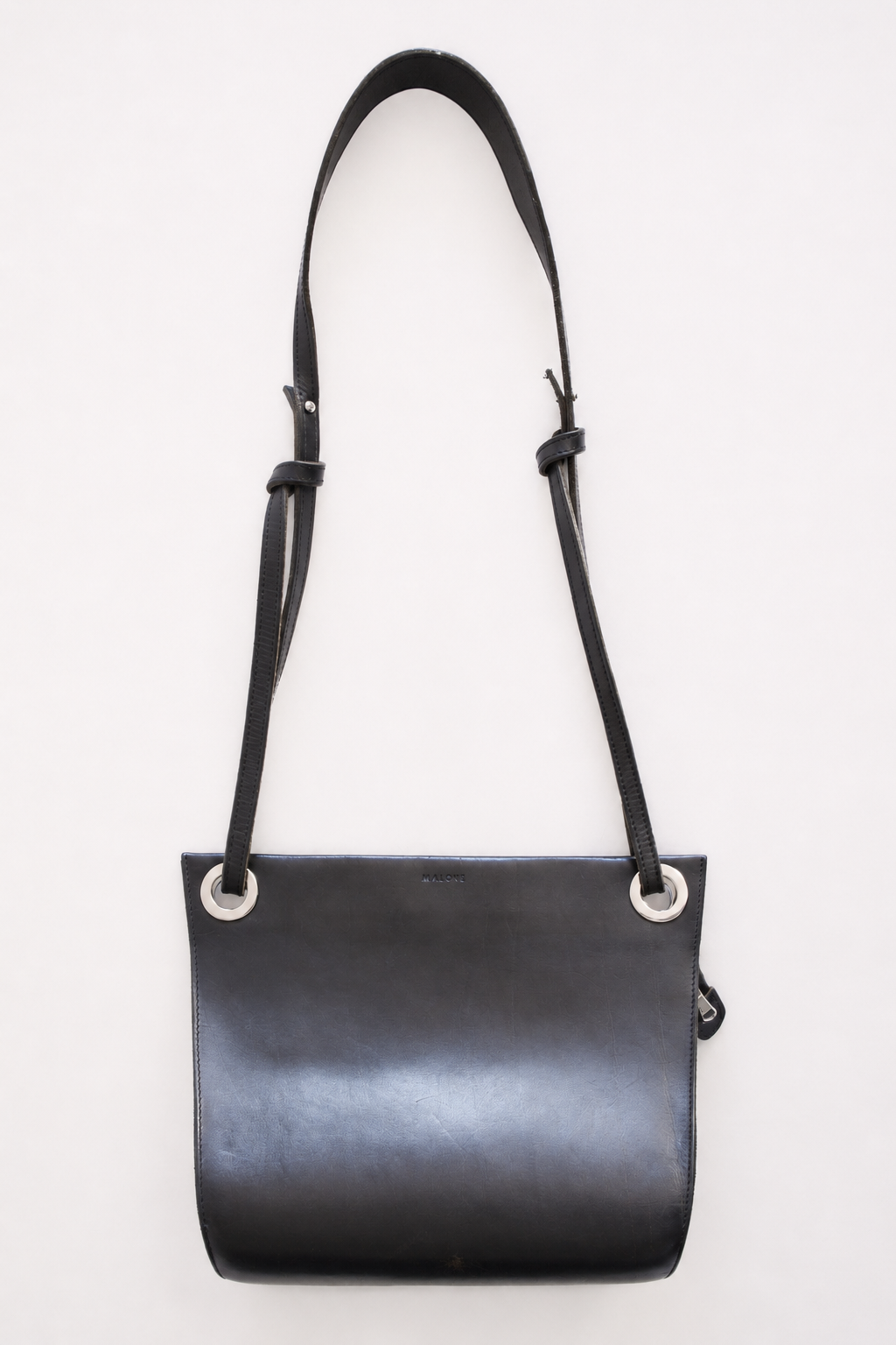 MALONE SLING — black leather crossbody bag, detail view of strap and hardware
