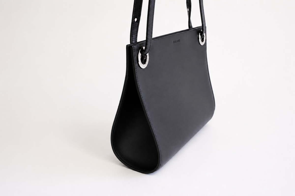 MALONE SLING — black leather crossbody bag, worn crossbody view